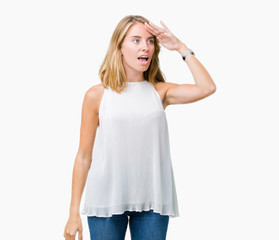Fototapeta premium Beautiful young elegant woman over isolated background very happy and smiling looking far away with hand over head. Searching concept.