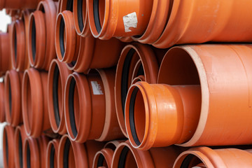 Orange PVC tubes in storage, Plastic tubes, Background of PVC