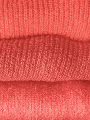 Pile of coral pink color woolen sweaters
