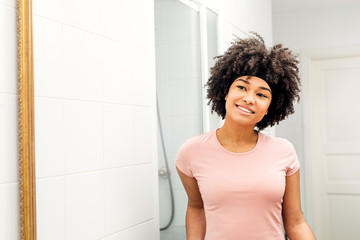 Smiling girl with hair bandage looking at mirror