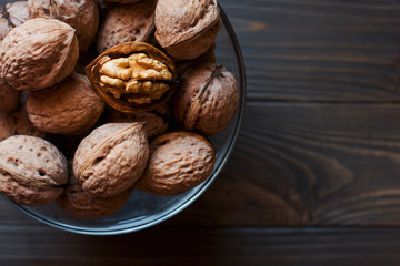 walnut bowl is standing on dark wooden background