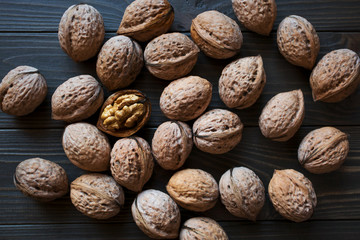 Greece nuts in the shell and open on a dark brown background