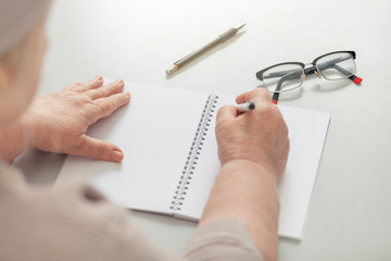 A woman takes notes in a notebook in the office.