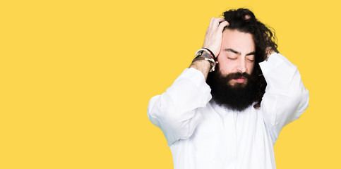 Man wearing Jesus Christ costume suffering from headache desperate and stressed because pain and migraine. Hands on head.