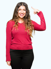 Obraz premium Young beautiful woman wearing red sweater Smiling pointing to head with one finger, great idea or thought, good memory