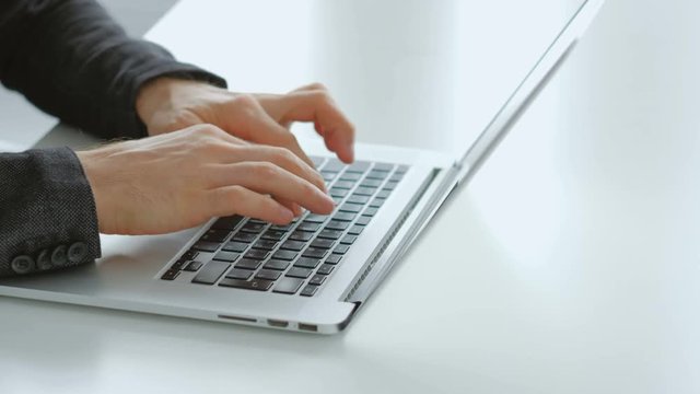 Freelance work or remote job. Self-employed man working on laptop. Hands typing on keyboard.