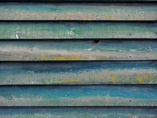 part of green wall on wooden barn with horizontal planks