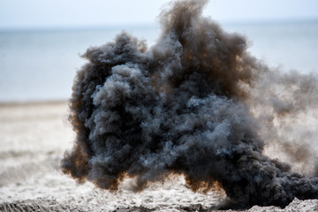 Explosion on the beach, billowing black smoke..