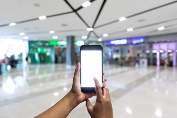 Closeup hand using mobile phone in department store.