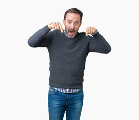 Handsome middle age senior man wearing a sweater over isolated background Pointing down with fingers showing advertisement, surprised face and open mouth