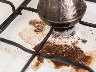 Cooking natural coffee. Coffee in Turk on the gas stove boiled away. Dirty stove. The incident in the kitchen