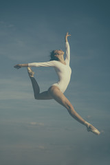Fototapeta premium Grace in every move. Practicing art of classical ballet. Ballerina jumping on blue sky. Cute ballet dancer. Pretty woman in dance wear. Ballet class. Classic dance style. Concert performance dance