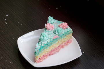 The piece is cut off and lies side by side on a saucer. Waffle cake made from cream soaked cakes. Decorated with cream flowers.