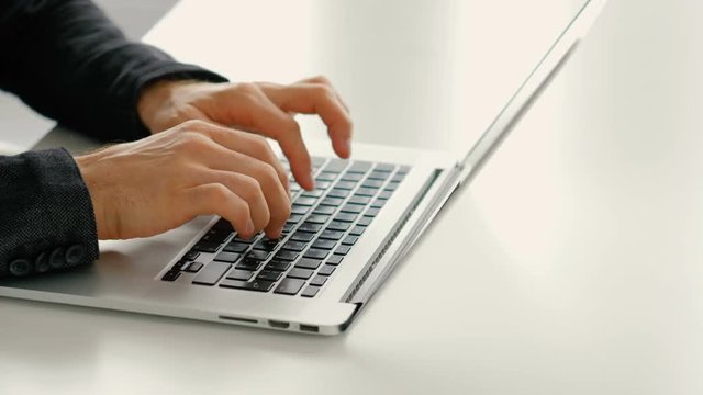 Speed typing and online reviews. Fast man hands on laptop keyboard.