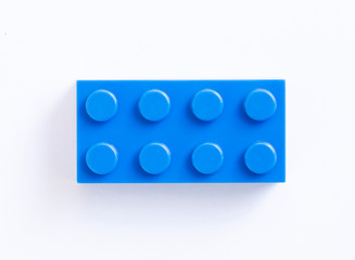 Blue plastic building block on white background