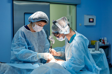 surgery, medicine and people concept - group of surgeons at operation in operating room at hospital