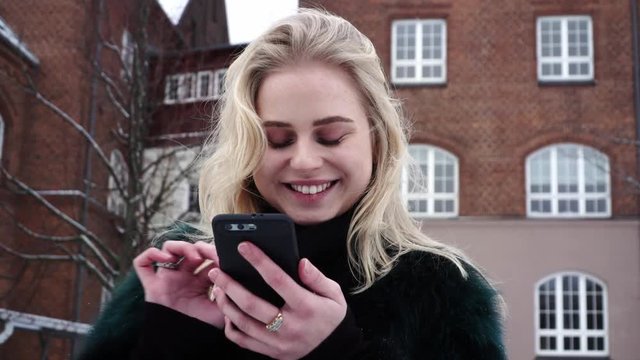 Happy and cute young beautiful teen girl is swiping on Tinder dating app left and right hoping to get a match and a date.