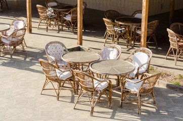 wooden chairs and round tables in an empty hotel cafe in Egypt Dahab South Sinai