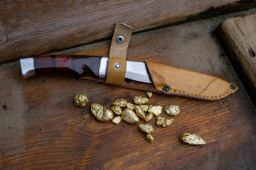 knife in the case and gold ore on wet boards