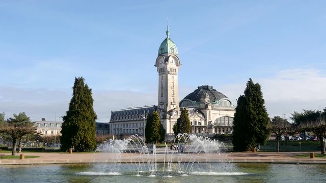 View of the famous Limoges station (called Limoges-B&eacute;n&eacute;dictins), in the centre-west of France. It is one of the city's most emblematic buildings. In the foreground, there are fountains. Sunny day.