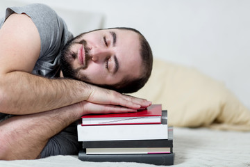 Obraz premium Young man is sleeping on his books. White background