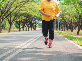 Fototapeta premium Overweight woman running in the park. Weight loss concept