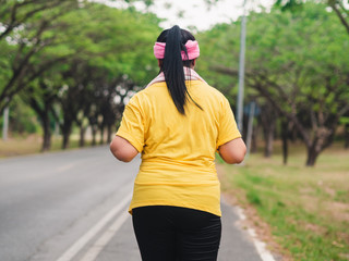 Overweight woman running in the park. Weight loss concept