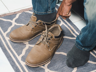 The man is wearing the shoes in the house .