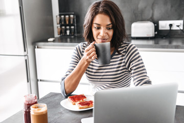 Smiling young african woman having breakfast