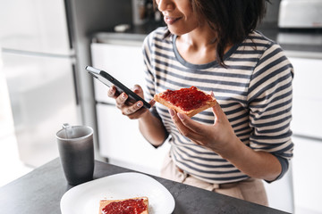 Beautiful young african woman having breakfast