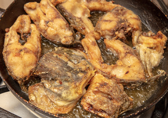 Fish is fried in a frying pan