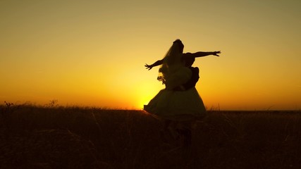 Young bride and groom circling on background of romantic red sunset. Honeymoon. The relationship between man and woman.