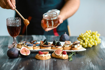 Sandwiches with cheese, fresh figs and honey on rustic wooden board Presentation on wooden table bruschetta with figs, cheese. top view