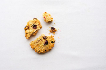 Broken oats and cranberry cookie on white background. Copy space