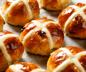 Hot cross buns, freshly baked hot cross buns on white parchment paper. Traditional easter food