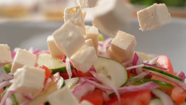 Camera follows putting diced feta cheese over salad. Shot with high speed camera, phantom flex 4K. Slow Motion.
