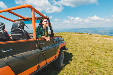 Obraz premium woman in off road cur at the top of the mountain. beautiful view on background. copy space