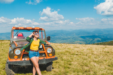 woman near off road cur at the top of the mountain. beautiful view on background. copy space