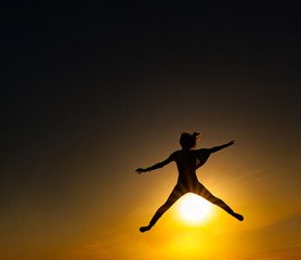 Silhouette of girl jumping during sunset