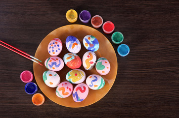painted Easter eggs, paintbrush and paint on the table. preparation for Easter. wooden table.