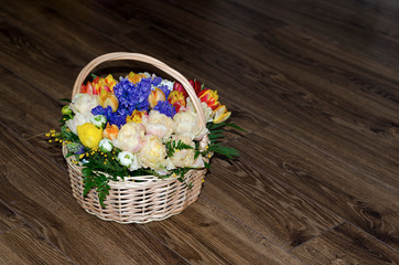 Fototapeta na wymiar Natural yellow roses and blue irises in a basket isolated on white background. Beautiful colorful fresh flowers for a gift.