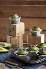 chocolate cupcakes with avocado frosting on wooden backdrop