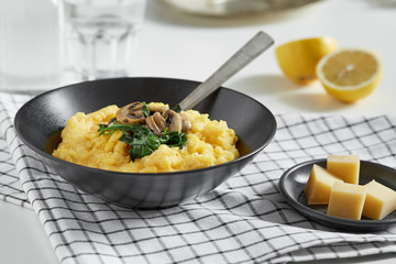 Polenta with mushrooms and spinach in a black bowl