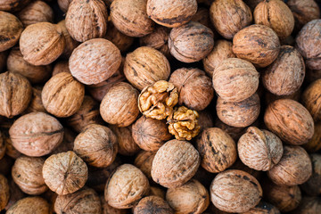 Walnut kernels on natural walnut pattern background, Raw bio walnuts texture, top view