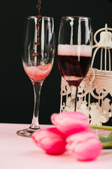glasses of red wine with flowers  on black background