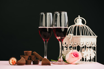 glasses of red wine with flowers  on black background