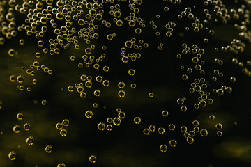 Champagne  bubbles soars over a golden background 