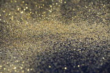 twinkling golden glitter falling on a flat surface lit by a bright spotlight (3d illustration)