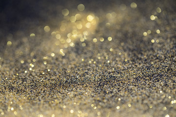 twinkling golden glitter falling on a flat surface lit by a bright spotlight (3d illustration)