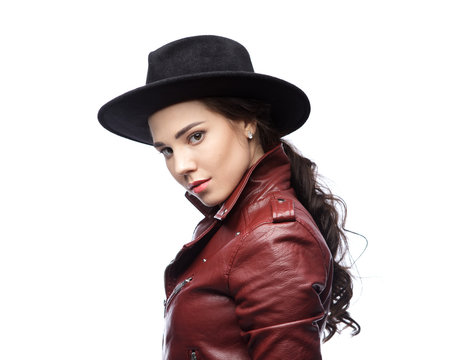 brunette woman wears a black hat and a leather jacket